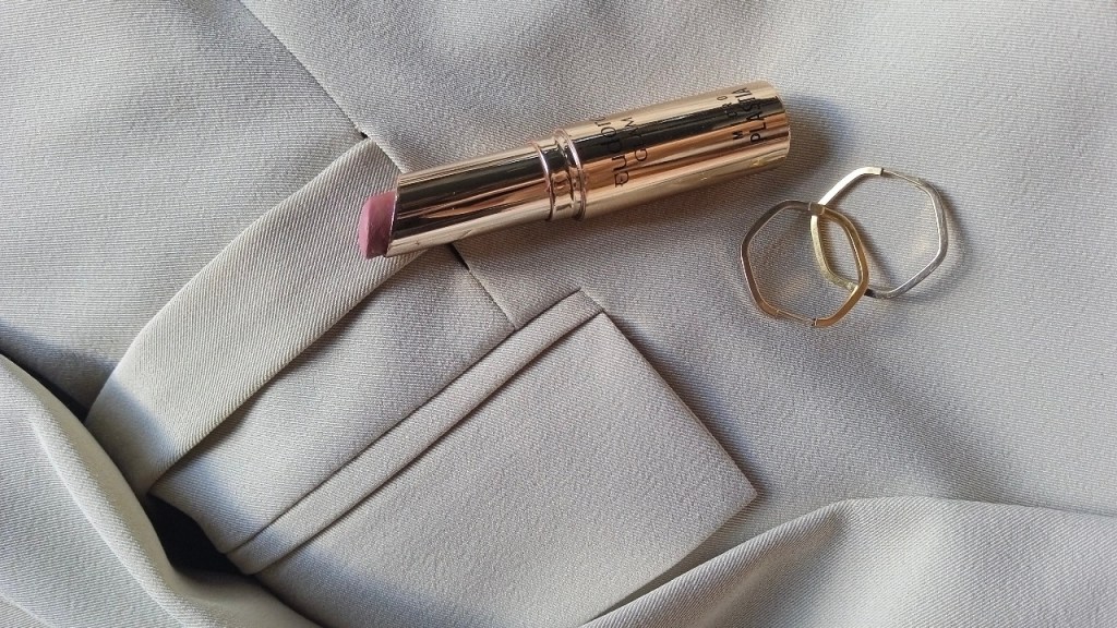 Lipstick, gold earrings and blazer flat lay — elevated style essentials.